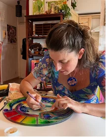 Fanny Chabrier peignant un disque de verre dans son atelier